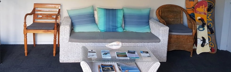 Guest lounge with coastal cushions and local brochures