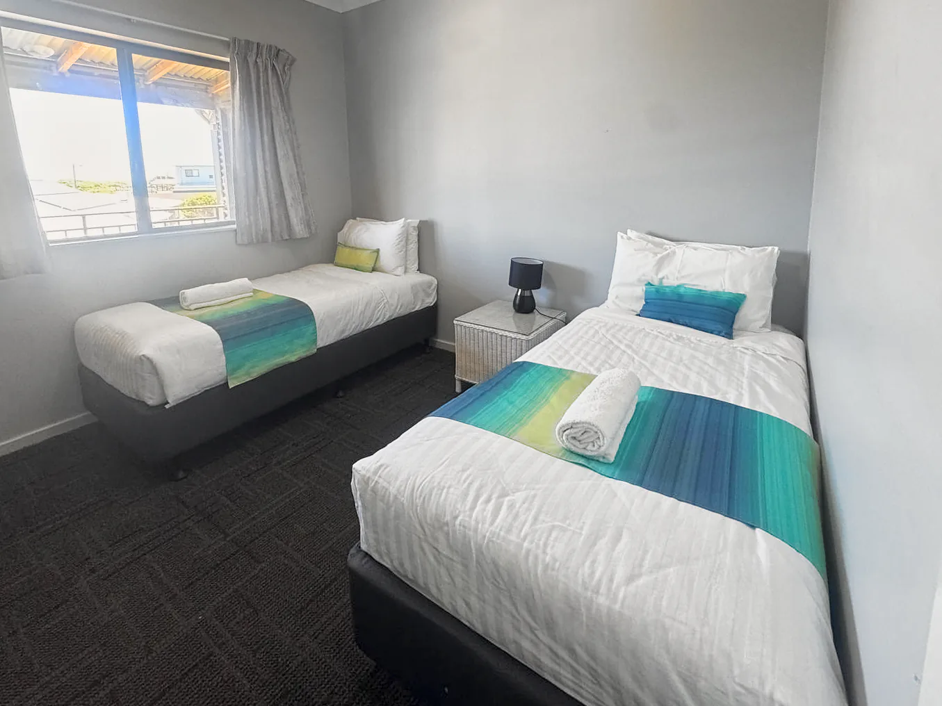 Second bedroom with two beds and a window in the 2-bedroom self-contained suite at Centre Break Beach Stay near Jurien Bay
